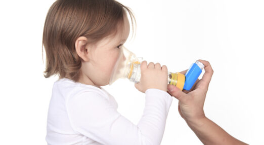 A child using an inhaler with a spacer