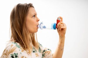 A young person using an inhaler with a spacer device